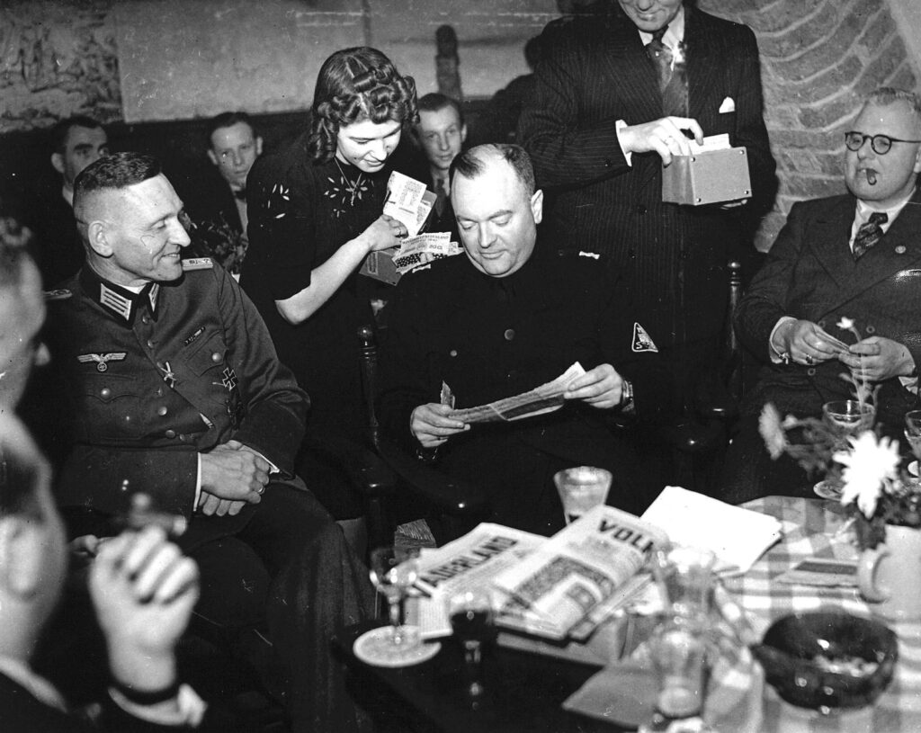 Viering van het tienjarig bestaan van de NSB. Mussert koopt een lot voor de nationaal-socialistische Winterhulp, 14 december 1941.