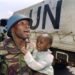 Ghanese VN-soldaat met een Tutsi kind in Rwanda