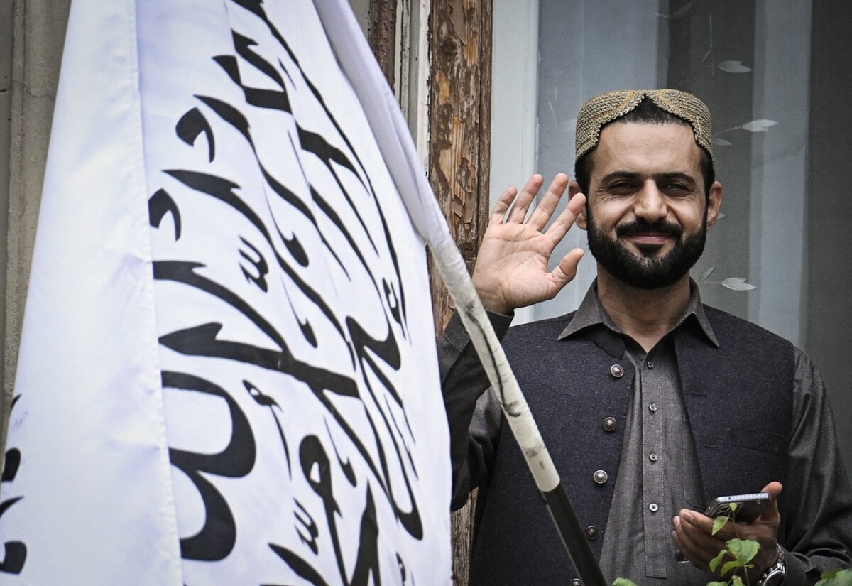 Een afgevaardigde zwaait op het dak van de Afghaanse ambassade in Moskou