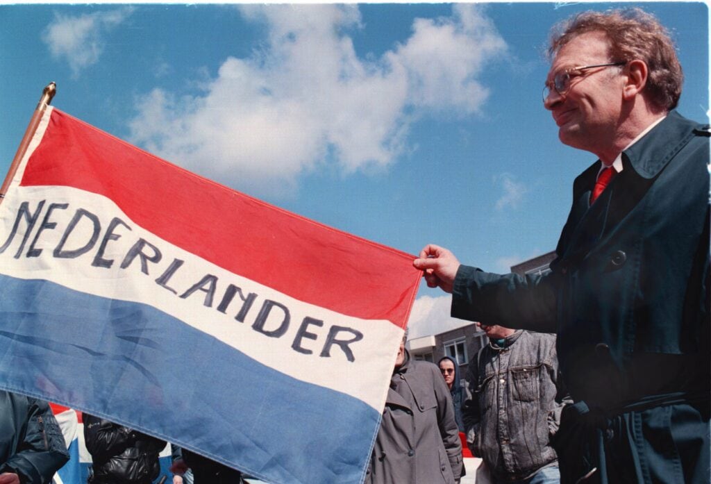 Hans Janmaat houdt een vlag vast bij een demonstratie van de Centrumdemocraten