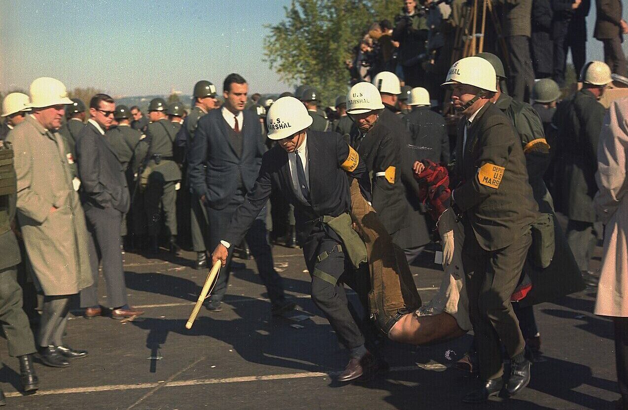 Marshalls dragen een Vietnamdemonstrant weg.