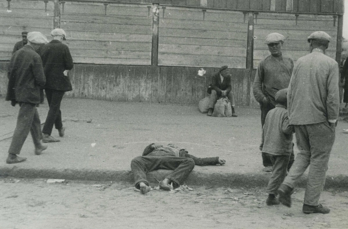 Voorbijgangers passeren een doodgehongerde man Charkov