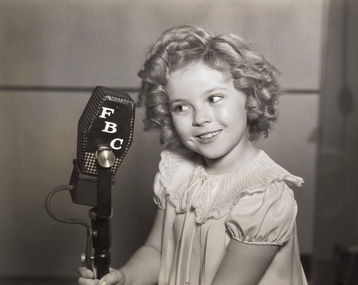 Shirley voor een microfoon van zender FBC in de jaren dertig.