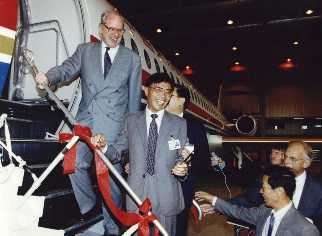 Minister van Economische Zaken Koos Andriessen bij de overdracht van Fokker 100-toestellen aan een Chinese delegatie in een hangar op Schiphol, 1 september 1992.