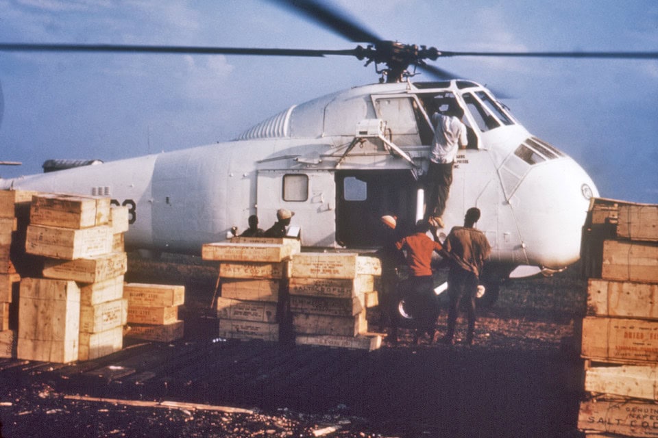 Hulpverleners halen kratten met gedroogde vis uit een helikopter tijdens de oorlog in Nigeria, 1968