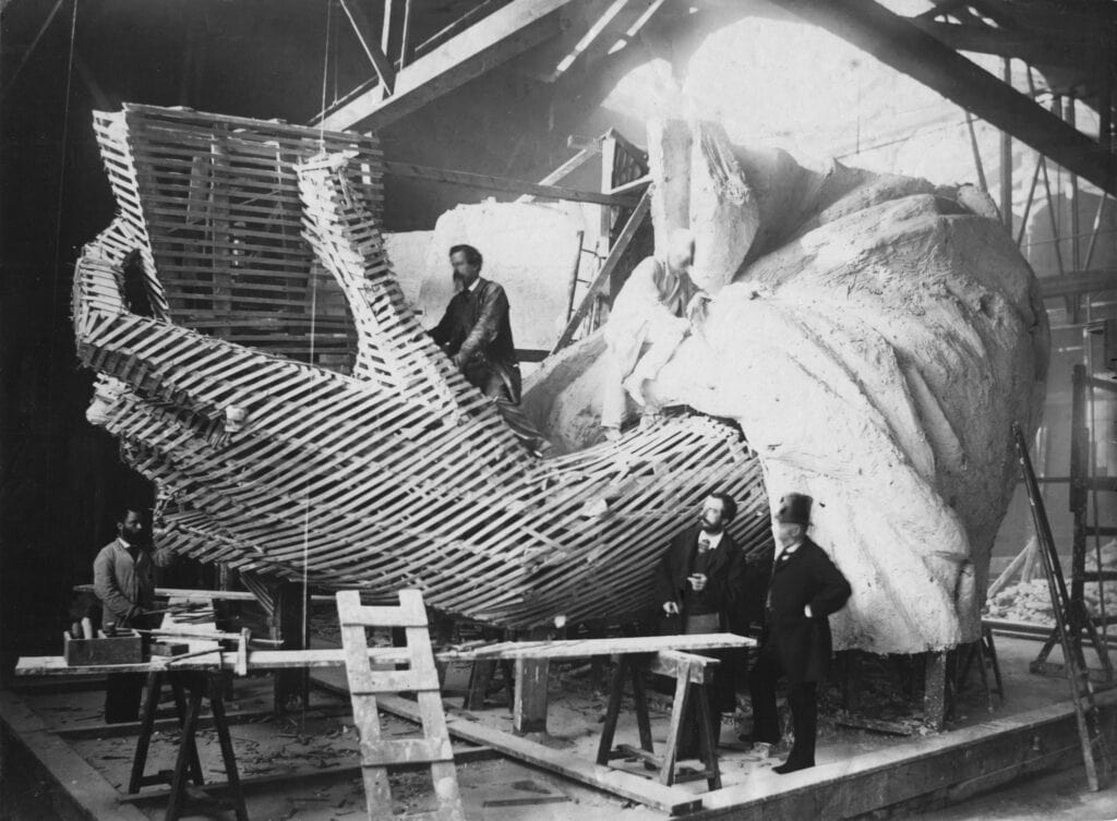 Bartholdi (tweede van rechts) bekijkt de skeletconstructie van de linkerhand van het Vrijheidsbeeld