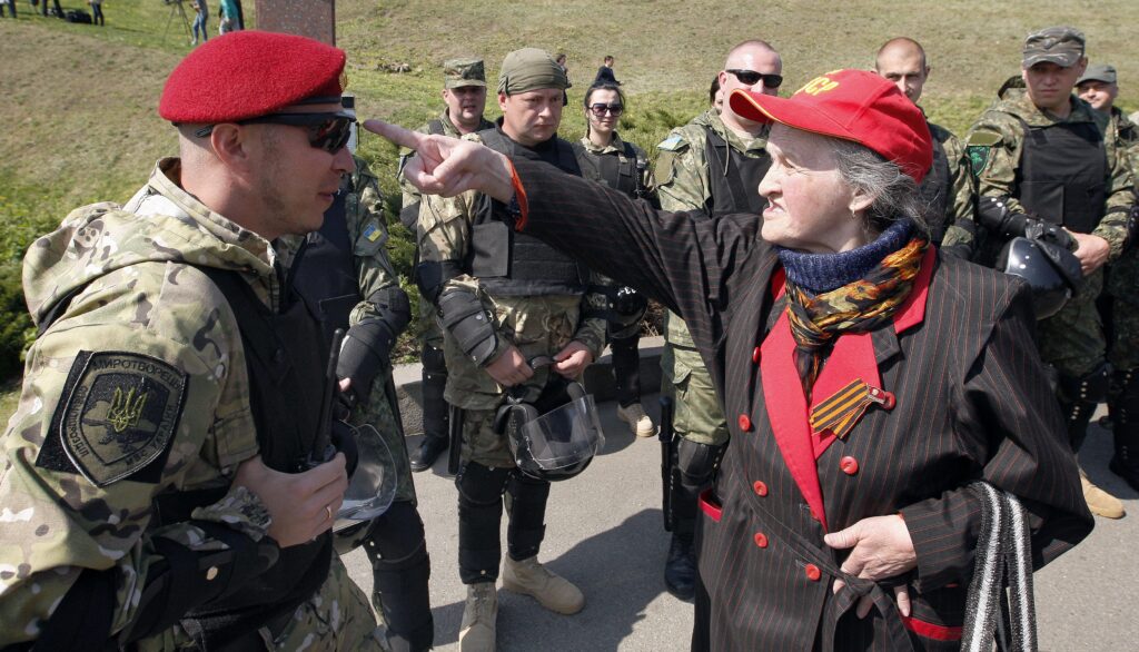 Een communiste ruziet met een politieagent tijdens een bijeenkomst van de Communistische Partij in Kyiv, 1 mei 2015. Op 9 april stemde het Oekraïense parlement voor een verbod op communistische propaganda en symbolen.