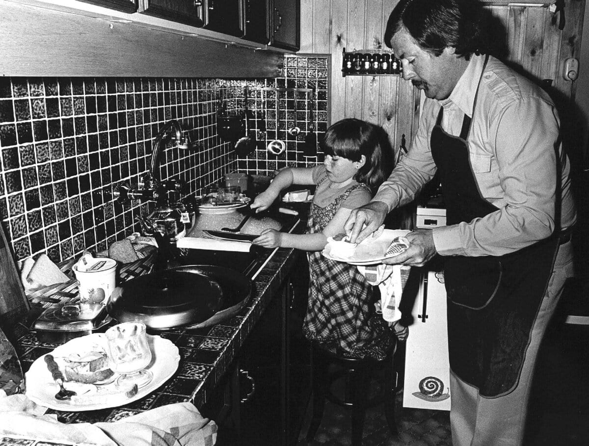 Een vader en zijn dochter doen samen de afwas op Moederdag, 1979.