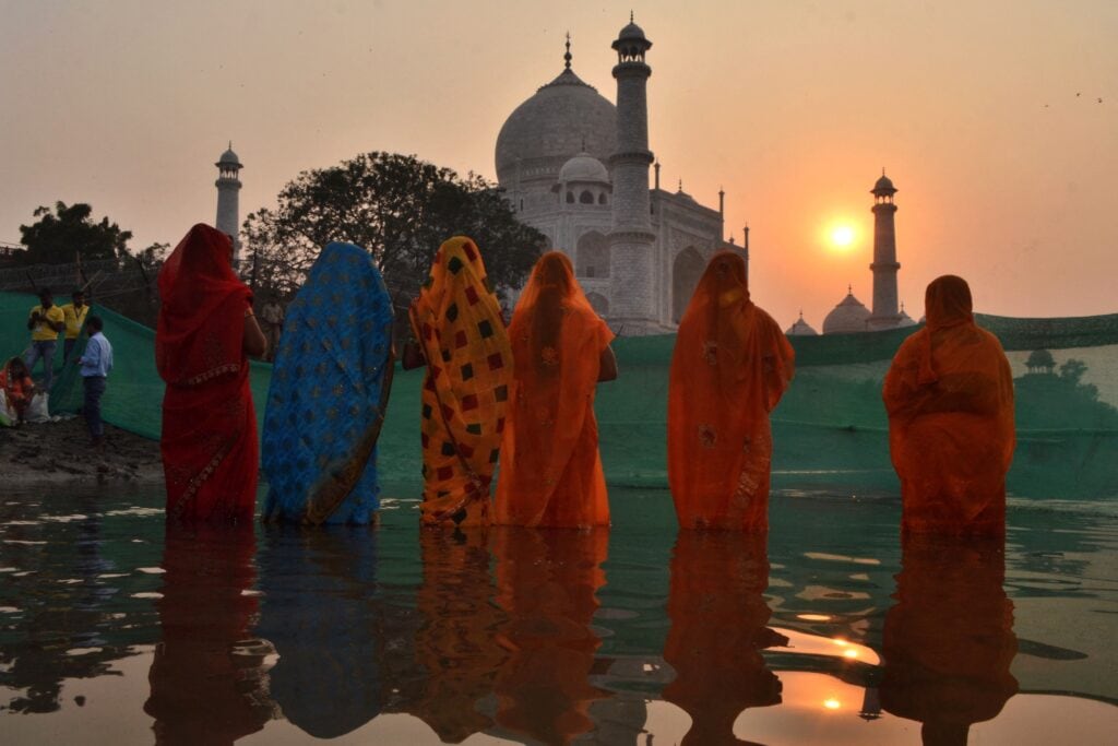 Hindoes aanbidden de zon bij de Taj Mahal. Agra, 20 oktober 2022.